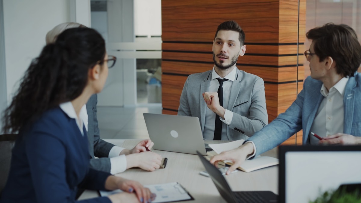 Recruiters and hiring managers discussing a search across a conference table in a modern office
